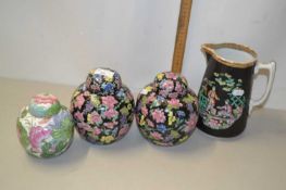 Two famille noir ginger jars and covers with floral decoration together with a further jar and a