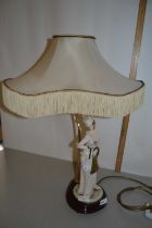 A continental porcelain lamp with a Capodimonte figure, impressed signature for B Merlin, the figure