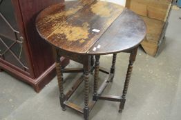 An oval drop leaf side table with turned legs