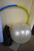 An exercise ball, weighted hula hoop and a carry-on/travel rucksack