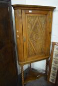 Pine corner cupboard on stand with carved front