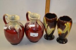 Pair of small German red glazed jugs together with a further pair of German vases (4)
