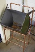 Vintage lawn mower grass box mounted on a copper frame to form a retro ice bucket