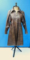 A brown leather coat by Bill Gibb, with round neck and button front, mutton sleeves and side pockets