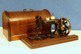 A late 19th century sewing machine, possibly German, with original carry case cover
