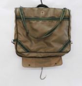 A Biba suit carrier, in beige canvas with green strapping