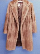 A ladies light brown 3/4 length mink coat, with two hook fastening, velvet lined pockets and brown