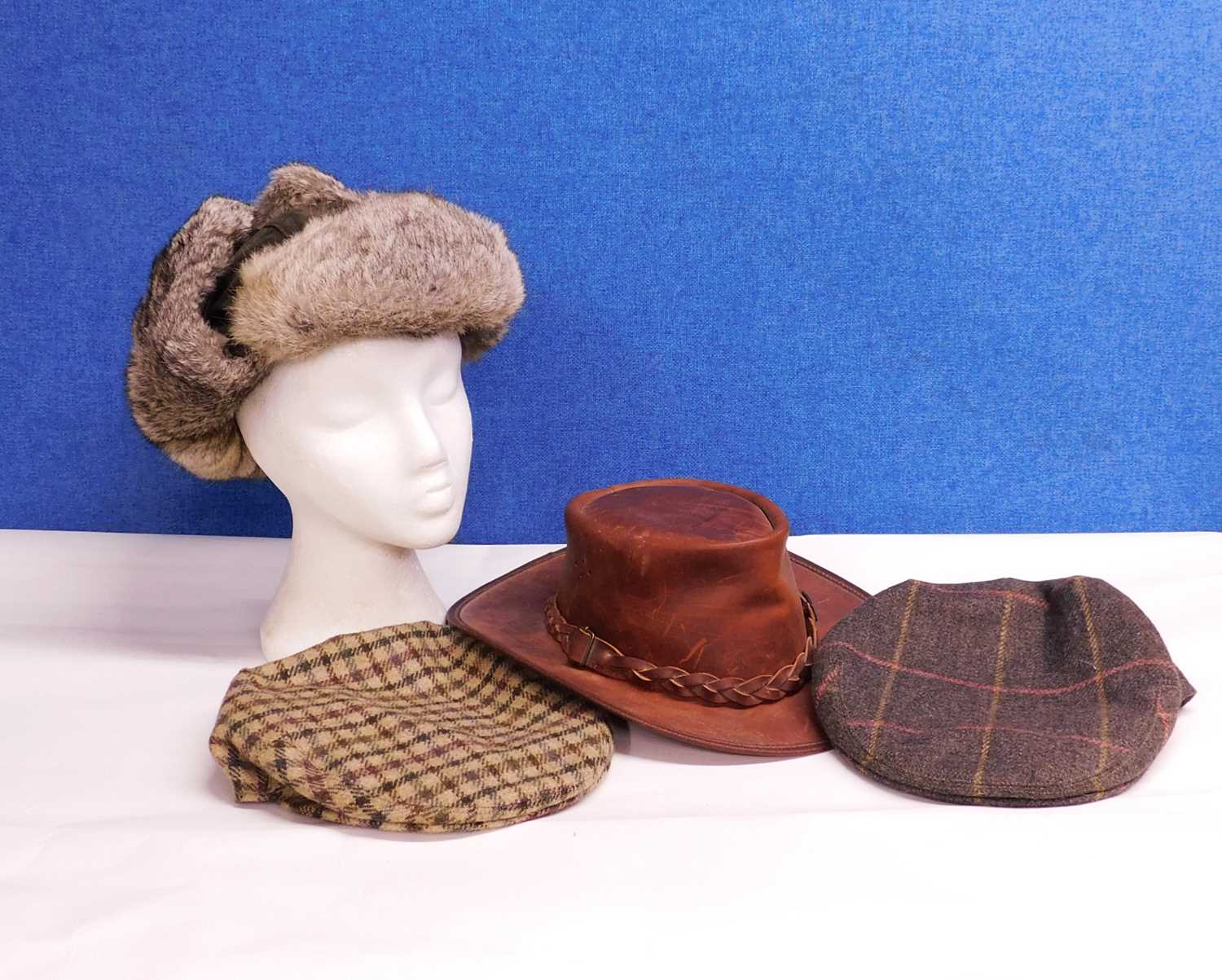 Four hats to include a tan leather hat by Toggi, size M, a fur trapper hat by Mountain Horse, one