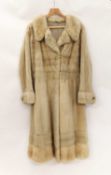 A ladies full length cream fur coat, with broad cuffs with faux pearl detail buttons, broad hem,
