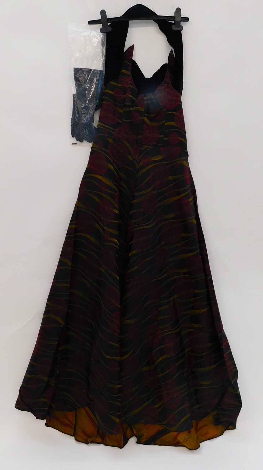 A lady's evening dress by Ricci Michaels of Mayfair, the halterneck dress with black red and gold