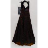 A lady's evening dress by Ricci Michaels of Mayfair, the halterneck dress with black red and gold