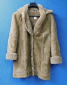 A beige sheepskin coat by Cole of Kent, the single breast coat with leather trim, detachable hood,