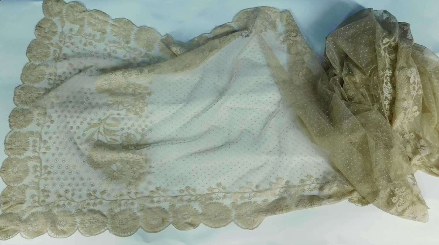 A Nottingham lace shawl with scalloped floral edges, with a border of flowers and all over dot and