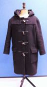 A lady's black duffle coat by Montgomery, single breasted with zip fastening and horn buttons, patch