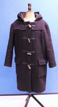 A lady's black duffle coat by Montgomery, single breasted with zip fastening and horn buttons, patch