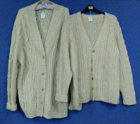 Two hand knitted cream woollen cardigans, one with horn buttons, the other with faux horn buttons (