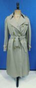 A lady's Burberry double breasted beige trenchcoat, with side pockets, buckle detail to cuff and