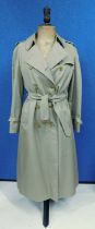 A lady's Burberry double breasted beige trenchcoat, with side pockets, buckle detail to cuff and