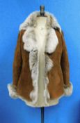 A lady's tan sheepskin jacket by Higgs, with tie front, side pockets, turn-back cuffs and