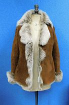 A lady's tan sheepskin jacket by Higgs, with tie front, side pockets, turn-back cuffs and