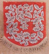 A beaded screen/penant, the red needlework background with all over beaded oak leaves and acorns,