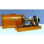 An early 20th century Singer sewing machine, in orginal wooden carry case with key