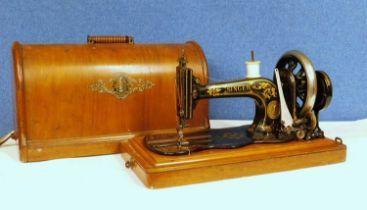 An early 20th century Singer sewing machine, in orginal wooden carry case with key