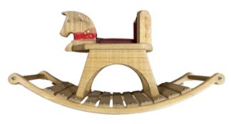 A small modern wooden rocking horse with red leather seat. Length approximately: 82cm