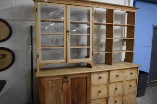 20th Century pine dresser cabinet of unusual form, the top with two glazed doors and shelved side