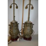 A pair of Chinese metal lamps decorated in archaistic fashion on wooden bases, lamp body is 32cm