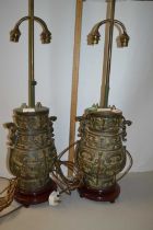 A pair of Chinese metal lamps decorated in archaistic fashion on wooden bases, lamp body is 32cm
