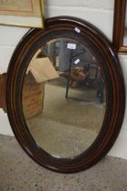 Oval bevelled wall mirror in dark wood frame