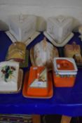 Two large triangle shaped cheese dishes and five others and a square storage jar