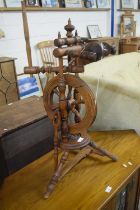 An antique turned wooden spinning wheel
