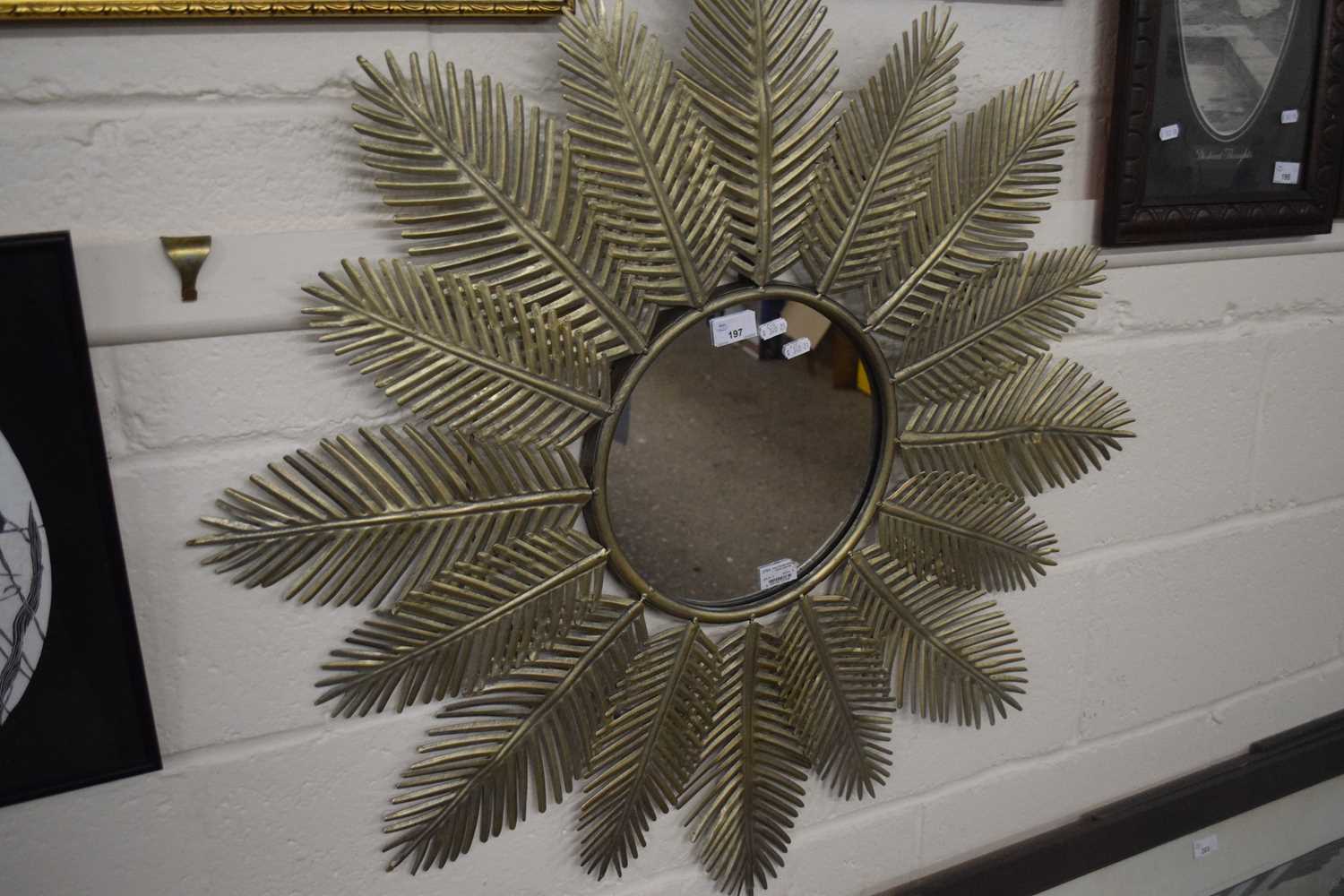 Sophisticated garden mirror with central circular mirror plate surrounded by metal palm leaf fronds