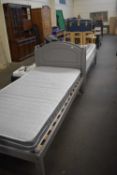 A pair of grey painted pine single beds