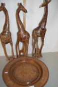 Three modern hardwood models of giraffe and a further carved wooden charger