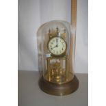 A brass anniversary clock set under a glass dome