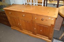 A pine sideboard of three drawers and cupboards below