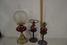 Three oil lamps with ruby glass fonts