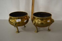 A pair of brass three footed jardinieres