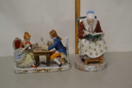 A continental porcelain figure group of a couple playing cards together with a further continental