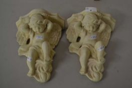 A pair of modern wall brackets decorated with cherubs