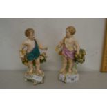 A pair of porcelain cherub figures with pseudo gold anchor marks