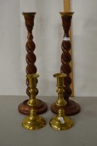 A pair of wooden barley twist candlesticks and a further pair of brass candlesticks