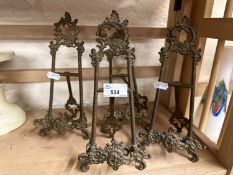 Four decorative brass free standing easels