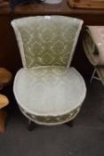 A sage green upholstered bedroom chair