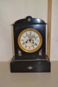 A Victorian black slate cased mantel clock with exposed escapement