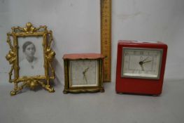 Two bedside clocks and a framed portrait photograph