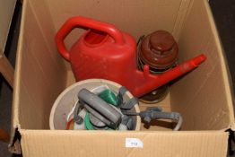 A weed sprayer, watering can and paraffin lamp